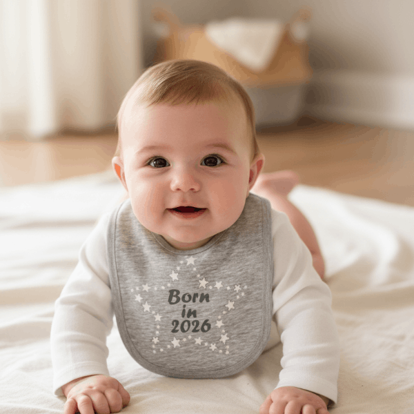 2026 baby bib on baby laying on the floor