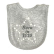 Grey baby bib with 'Born in 2026' text and star patterns on a white background