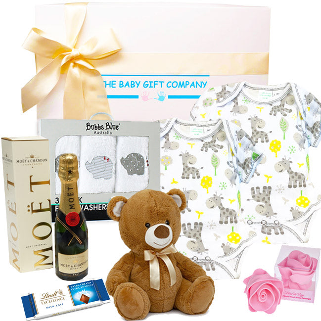 Collection of gifts including a teddy bear, Lindt Lindor chocolate box, moet with teddy bear from The Baby Gift Company.