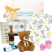 Collection of gifts including a teddy bear, Lindt Lindor chocolate box, moet with teddy bear from The Baby Gift Company.