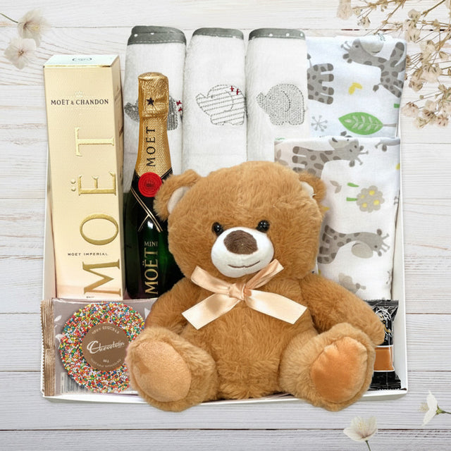 Collection of gifts including a teddy bear, Byron bay fudge, Moet with teddy bear from The Baby Gift Company.