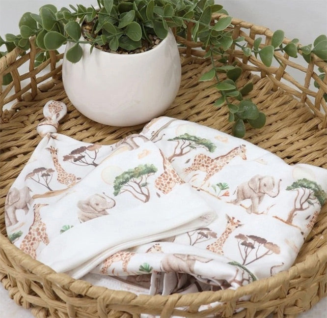 Baby blanket with animal pattern in a woven basket with a plant