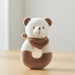 Plush panda toy with a brown ring and scarf on a table