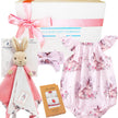 Baby gift set with pink bunny-themed romper, plush toy, headband, and socks from 'The Baby Gift Company'.