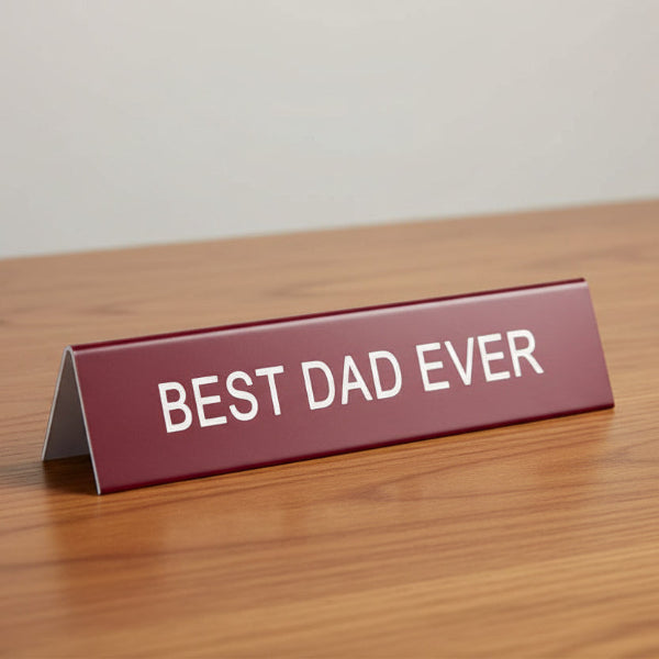 Red sign with 'BEST DAD EVER' text on a table background