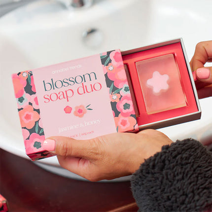 Blossom soap duo packaging with a pink soap bar inside, held by a person.