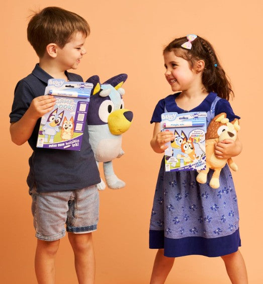 Two children holding toys and packages against an orange background