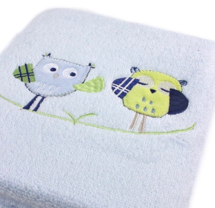 Two embroidered owl designs on a light blue fabric background