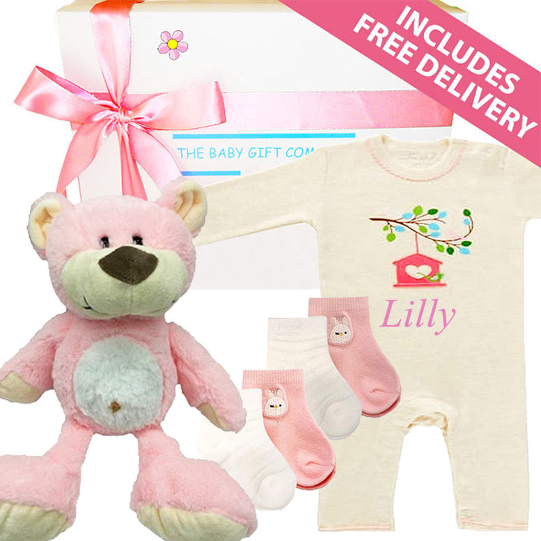 Baby gift set with teddy bear, onesie, and socks on a white background