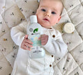 Baby holding a Dr. Organic product on a patterned blanket
