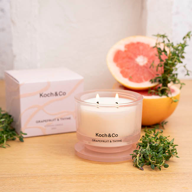 Koch & Co candle with grapefruit and thyme on a wooden surface