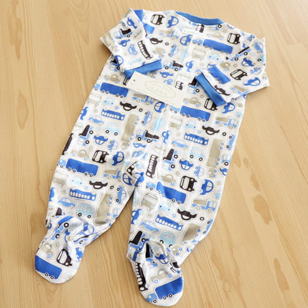 Baby onesie with vehicle pattern on a wood background