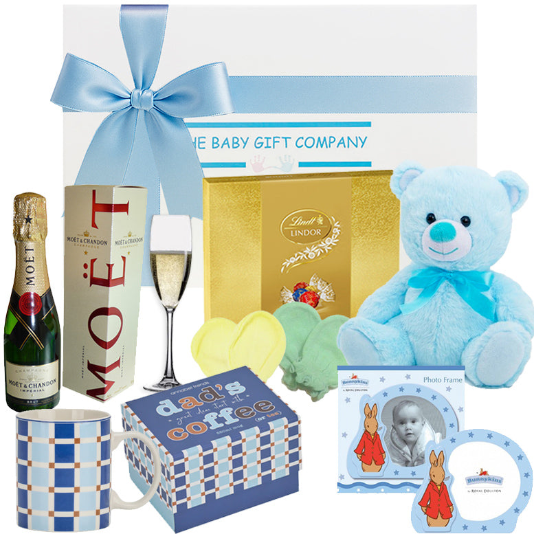 Gift basket with baby items including a teddy bear, bottle, and photo frame.