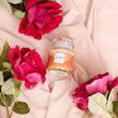 Champagne Rose Scented Candle on a fabric and floral background