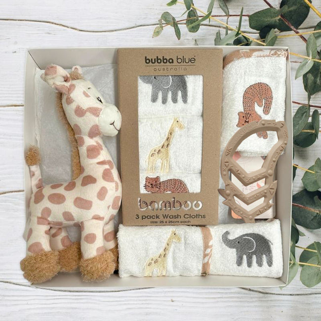 Bamboo wash cloths by Bubba Blue with a plush giraffe toy and silicone feather teether in baby gift box on a light wooden surface.