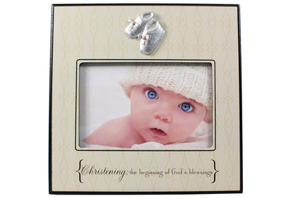 Decorative photo frame with baby picture and decorative booties on a white background