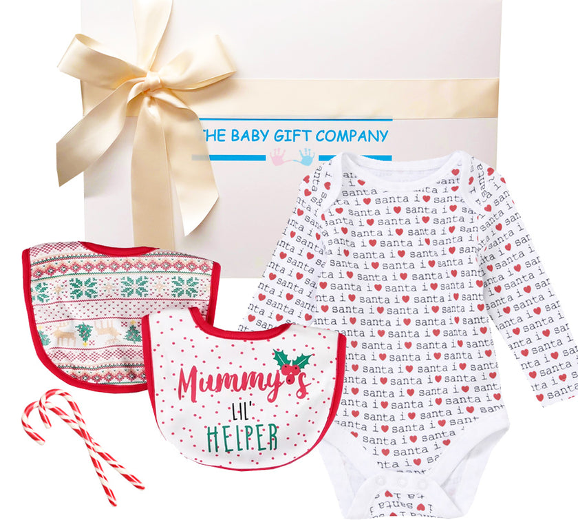 Christmas Baby Gift box with teddy bear, onesie, candy canes, and snow globe on a white background.