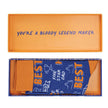 Orange box with blue text and a pair of socks inside, featuring text Best Dad