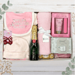 Baby outfit with stripe pattern, Moet Champagne, hand lotions and pink blanket in a gift box from The Baby Gift Company