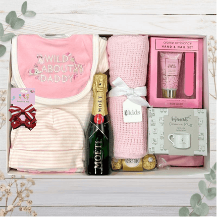 Baby outfit with stripe pattern, Moet Champagne, hand lotions and pink blanket in a gift box from The Baby Gift Company