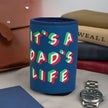 Blue can cooler with 'It's a Dad's Life' text on a surface with books and a watch.
