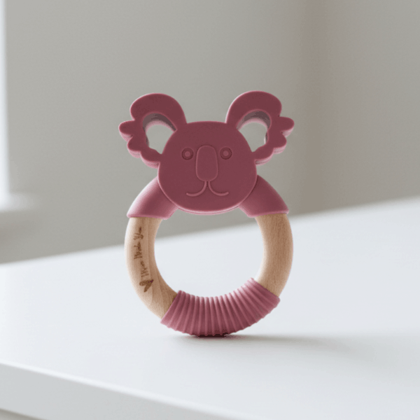 Pink koala-shaped teething ring on a table