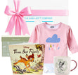 Baby gift set with pink shirt, mug, and book featuring Disney characters, branded 'The Baby Gift Company'.