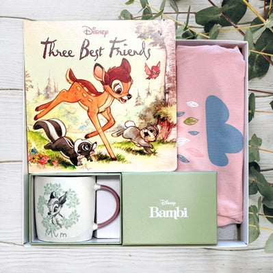 Disney Bambi themed gift set with mug, book, and towel on a wooden surface.