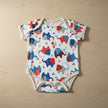 Baby onesie with colorful animal elephant pattern on a table