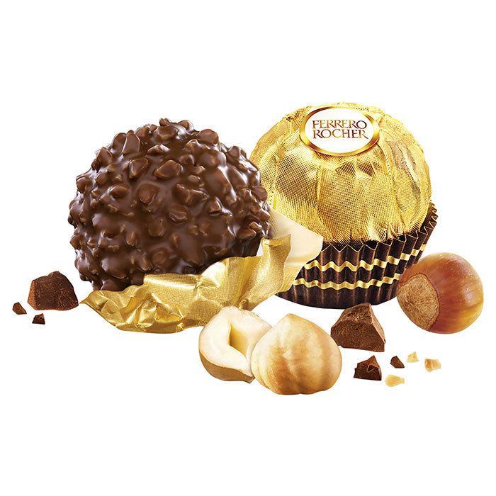 Ferrero Rocher chocolate with gold wrapping and hazelnuts on a white background