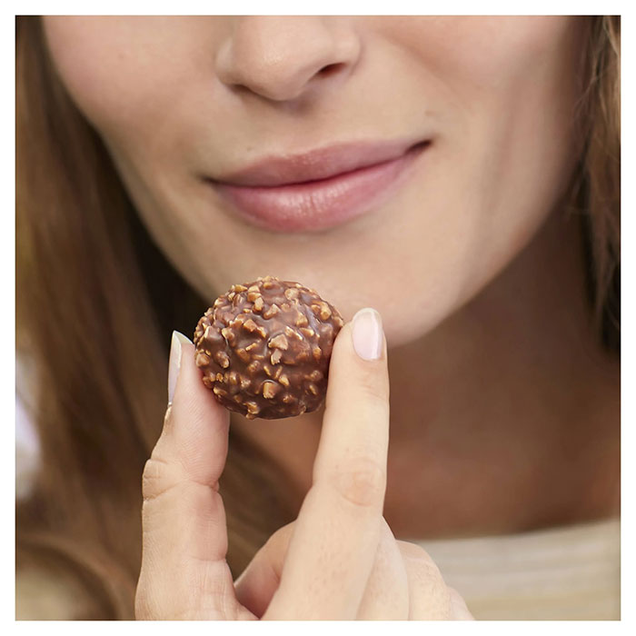 Close-up of a woman holding a Ferrero Rocher chocolate