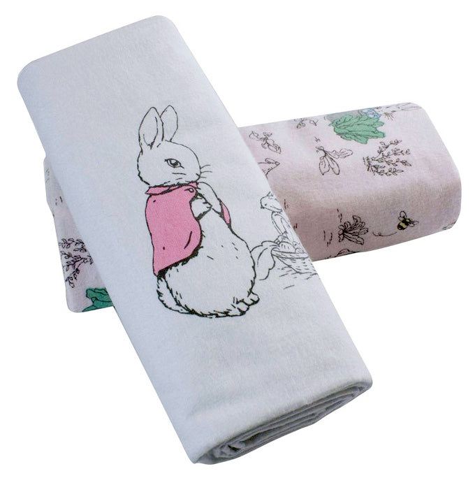 Two folded towels with a flopsy rabbit design and nature-themed pattern on a white background