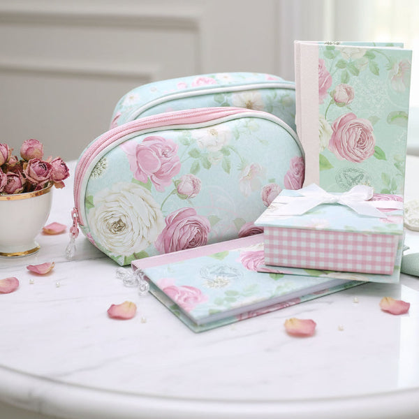Set of floral and checkered products including a pouch, notebook, and pouches on a table