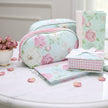 Set of floral and checkered products including a pouch, notebook, and pouches on a table