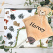 Green forest baby blanket and teddy bear with 'Harvey' embroidered, in a box with greenery background