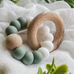 Foxx & Willow Silicone & Wood Baby Teether on white fabric