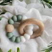 Foxx & Willow Silicone & Wood Baby Teether on white fabric