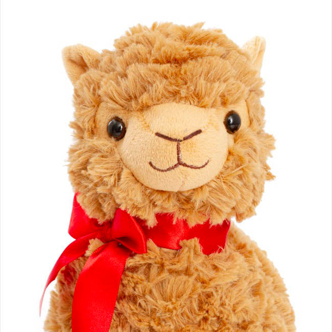 Plush toy llama with a red bow on a white background