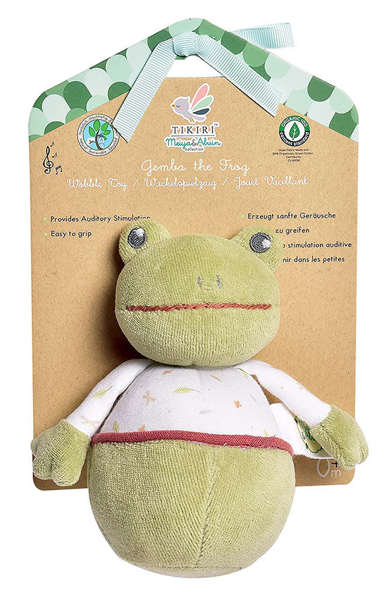 Green plush toy frog with a white bib on a brown card with branding