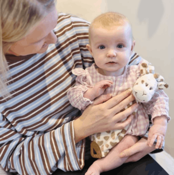Mother holding baby with Giraffe Doudou toy