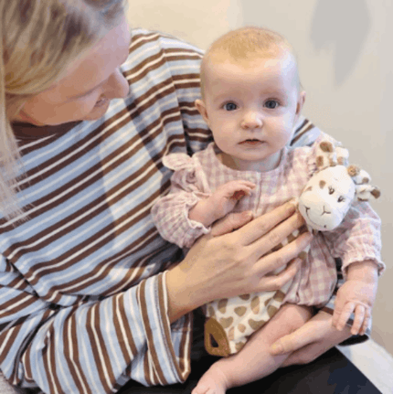 Mother holding baby with Giraffe Doudou toy
