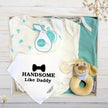 Baby gift set with baby boy onesies, handsome like daddy bib, and rattle in a gift box.