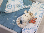 Baby clothing and toys with blue and white patterns on a light surface