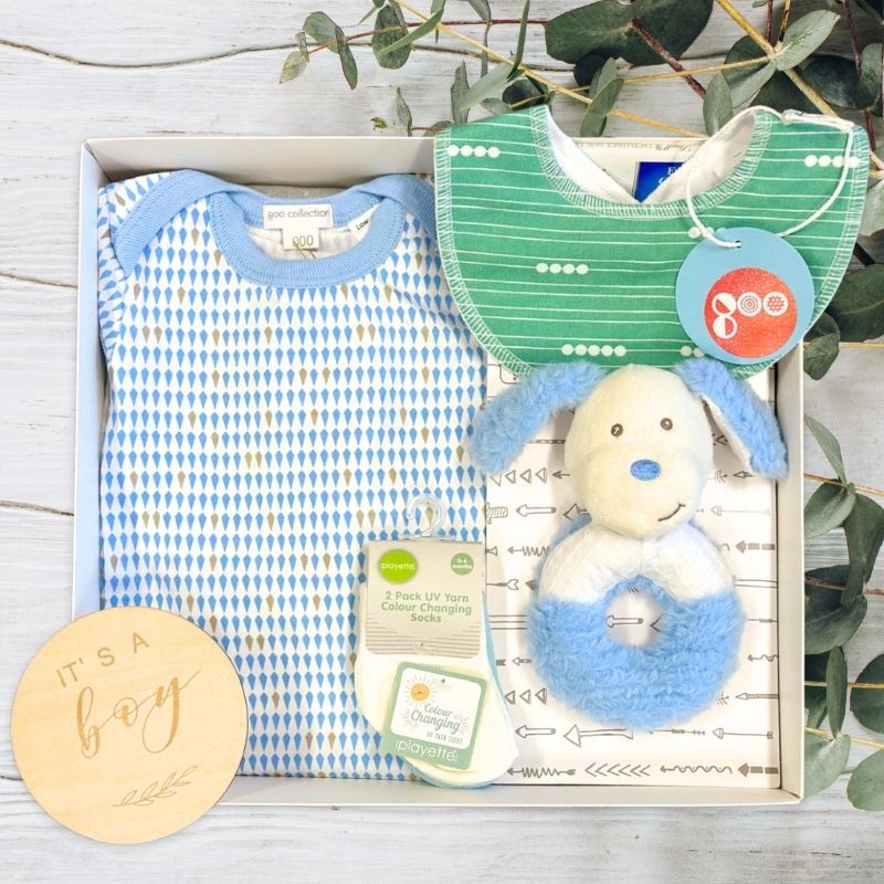 collection of baby boy gifts, clothes and toys in gift box