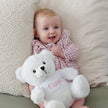 Baby sitting on a chair with Its a Girl Teddy Bear