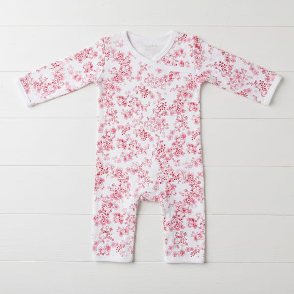 Baby onesie with red floral pattern on a white background