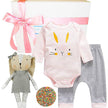 Baby outfit with onesie, pants, and plush toy on a white background
