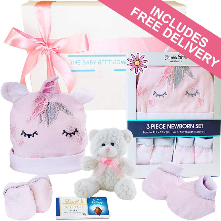 Baby gift set with pink unicorn hat, teddy bear, and baby clothes with free delivery text.