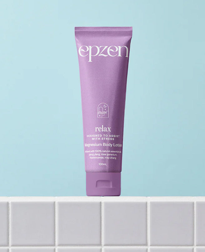Purple tube of epzen magnesium body lotion on a tiled surface with a light blue background