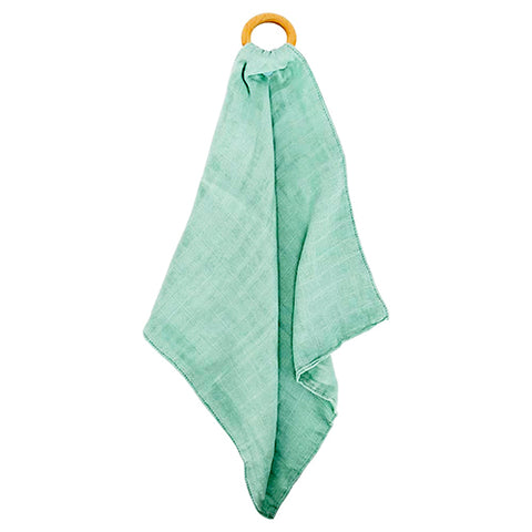 Green towel hanging on a wooden ring against a white background